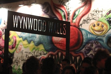 People pass by the Wynwood Walls exhibit on Saturday during February's Art Walk. The Wynwood Walls are a collection of murals and graffiti on warehouse walls in Downtown Miami. The project started in 2009.  File Photo