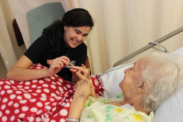 During the UGenerations visit to the Floridean Nursing Home on Saturday morning, Junior and Vice President of UGenerations, Gaby Lins gives resident Gladys Martinez a manicure. Hallee Meltzer// Staff Photographer