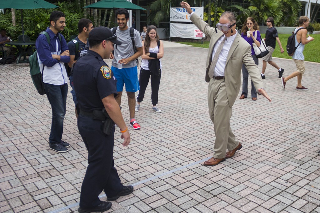 Wearing googles that simulate alcohol impairment, Dean of Students Ricardo Hall attempts to complete a sobriety test. The annual safety fair took place on Thursday at the Rock. This year, the Florida Department of Transportation District Six partnered with UM to promote a “Put It Down” campaign. The fair featured booths offering information about texting and driving, and a a car roll simulator showed students the impact of rollover accidents. Mothers Against Drunk Driving handed out brochures and Ms. University of Miami promoted her campaign against texting and driving. Victoria McKaba // Staff Photographer