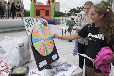 Adeline Lange spins the wheel at the UHonor event at the Patio on Wednesday. UHonor was tabling to promote academic integrity across campus. 