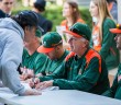 Baseball head coach Jim Morris signs posters and other memorabilia for fans during February’s Fan Fest held at Alex Rodriguez Park at Mark Light Field to open the 2015 season. File Photo by Nick Gangemi