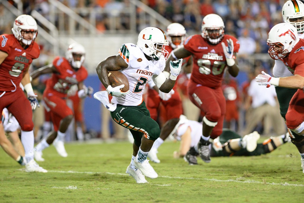 Sophomore running back Joseph Yearby (2) runs the ball through FAU defenders during Friday's game at Howard Schnellenberger Field at FAU Stadium. The Canes won 44-20, extending their winning record to 2-0 record. Courtesy Jessica Marshall // Caneshooter.com
