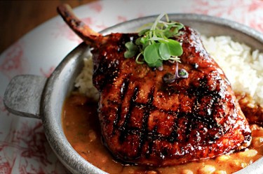 Finka Table and Tap, which blends together Peruvian, Korean and Cuban cuisines in their dishes, features a Pork Chop with Asian glaze, Frijoles Canarios, and white rice. Courtesy Finka Restaurant