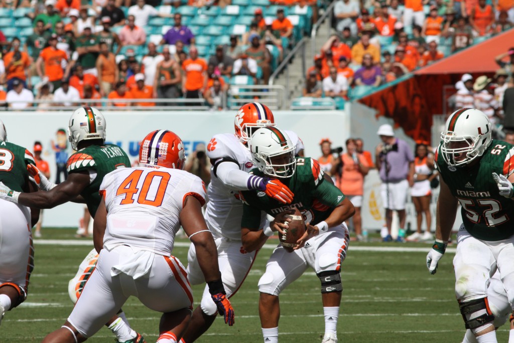 Sophomore quarterback Brad Kaaya (15) takes a hit from Clemson defenders in the first quarter of last week's game against Clemson. Kaaya later left the game after getting sacked early in the second quarter. Hallee Meltzer // Photo Editor