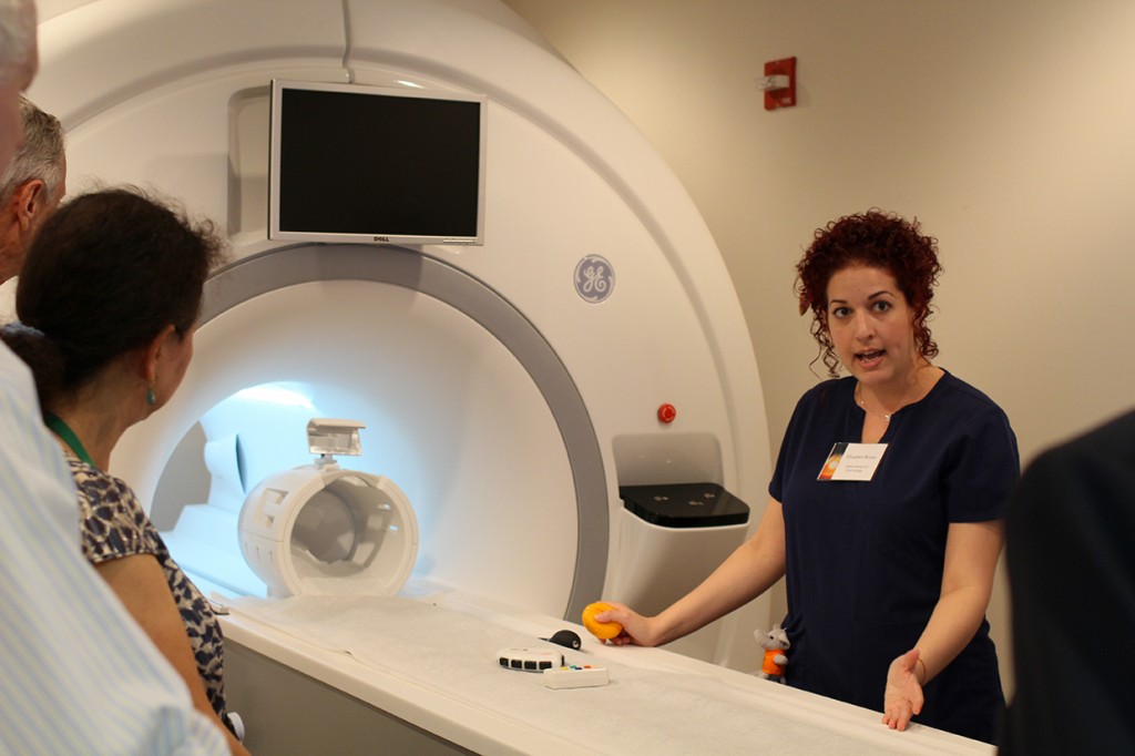 Elizabeth Reyes, an administrative assistant at UM's Department of Psychology, demonstrates the new fMRI equipment at Friday's Neurosicence Facility Open House. Erum Kidwai // Staff Photographer
