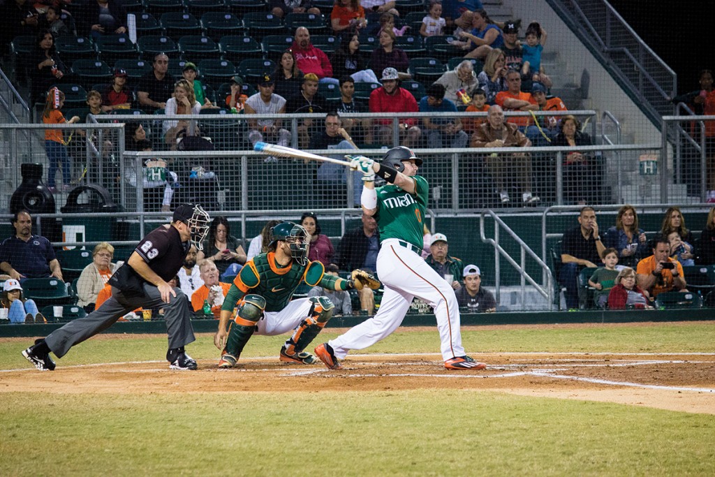 Junior catcher Zack Collins (0) hits during his at-bat during the Alumni game hosted at Mark Light Field at Alex Rodriguez Park Saturday night. Giancarlo Falconi // Staff Photographer