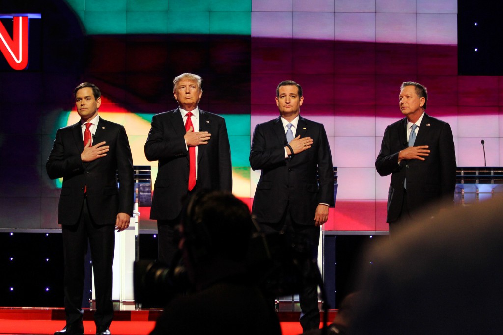 The four Republican candidates, Marco Rubio, Donald Trump, Ted Cruz and John Kasich hold their hands to their hearts during the National Anthem before the start of the GOP Debate Thursday night at the BankUnited Center. Victoria McKaba // Assistant Photo Editor