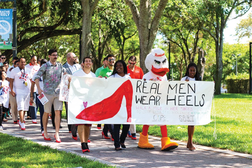 Students strut through campus in red heels as part of Walk A Mile in Her Shoes hosted by Counseling Outreach Peer Education and Sexual Assault Resource Team Thursday afternoon. The walk raised awareness for domestic abuse and sexual assault. Kawan Amelung // Staff Photographer