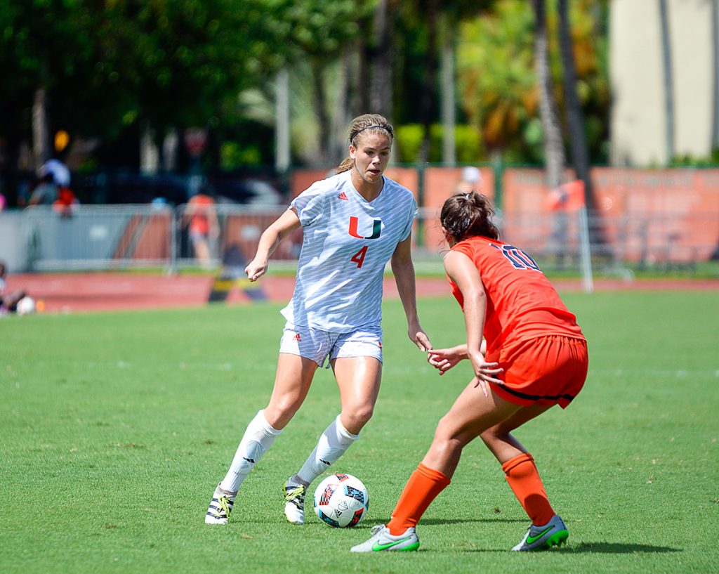 Junior forward Ronnie Johnson (4) challenges a Syracuse player during the women's soccer's 2-0 win Sunday afternoon at Cobb Stadium. Johnson scored one of the two Hurricane goals. Josh White // Contributing Photographer