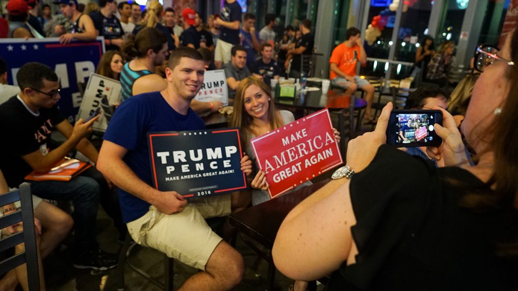 Trump supporters have their photo taken with “Make America Great Again” signs at the Rathskeller Tuesday night. Hunter Crenian // Staff Photographer