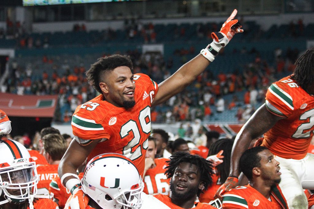 Senior defensive back Corn Elder (29) sits on the shoulder of his teammate and sings the alma mater as the team celebrates their seniors Saturday night after the Canes' win at Hard Rock Stadium. Victoria McKaba // Photo Editor
