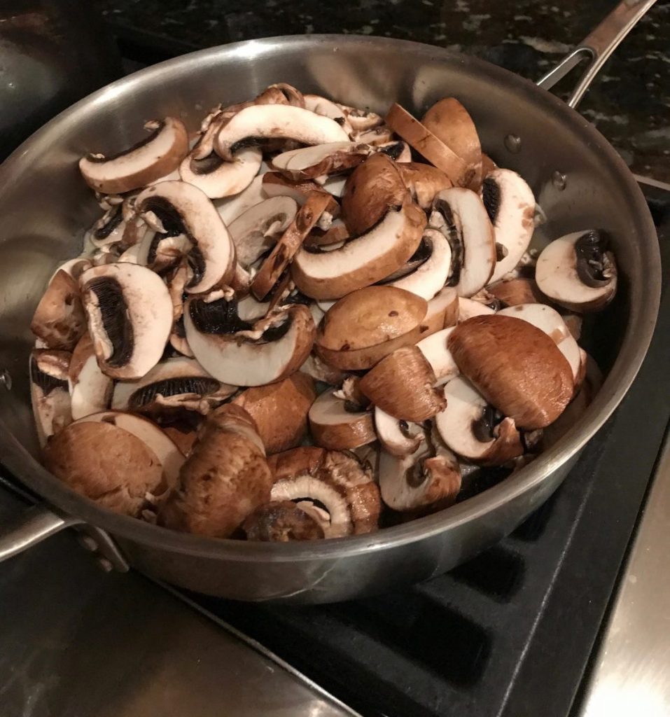 Mushrooms are put into a pot to sauté and later be added to the chicken and onions.