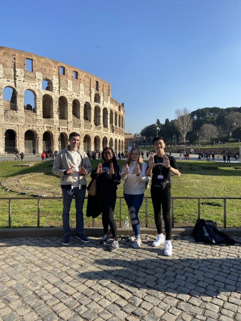 From left, students Jake Triarsi, Kayla Gardner, Grace Harrington and Brian Truong through up the U outside the Roman Colosseum.