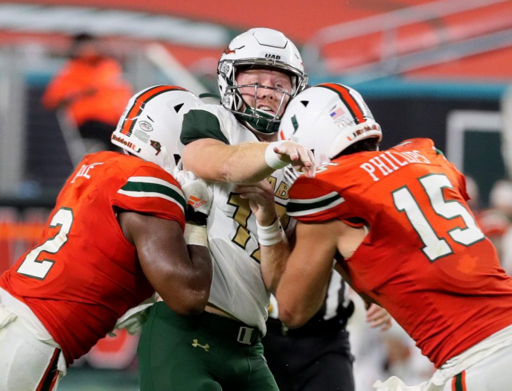 Defensive linemen Quincy Roche (2) and Jaelan Phillips (15) crush UAB quarterback Tyler Johnson III (17) in the third quarter as the University of Miami hosts the UAB Blazers at Hard Rock Stadium on Thursday, September 10.