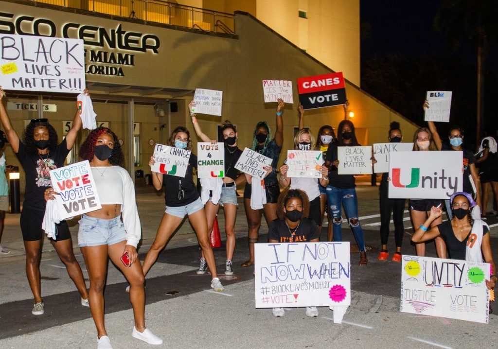 Student athletes gather outside of the Watsco Center for a social justice rally, protesting for societal change and encouraging people to vote.