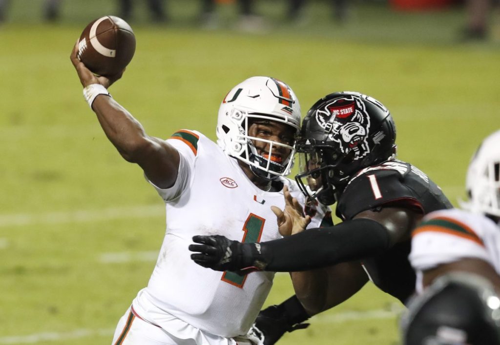 Quarterback D'Eriq King (1) passes as N.C. State linebacker Isaiah Moore (1) pressures him during the second half of Miami’s 44-41 victory over N.C. State at Carter-Finley Stadium in Raleigh, North Carolina on Friday, Nov. 6.