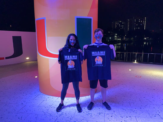 UM students, junior Greeshma Venigalla, left, and junior Kyle Rowley, right, show off their giveaways following their cycle session on Lakeside Patio stage on March 25.