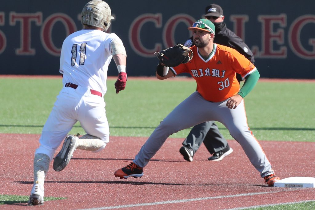 Alex Toral awaits a throw to first base as a BC player runs to first base. The Canes lost the series 2-1 to the Eagles.