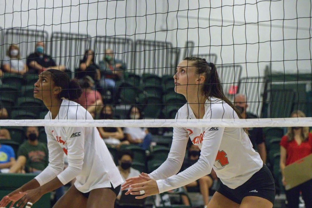 Redshirt sophomore outside hitter Angela Grieve and junior middle blocker Janice Leao prepare for a serve during Miami's match against USF at the Knight Sports Complex on Sept. 5, 2021.