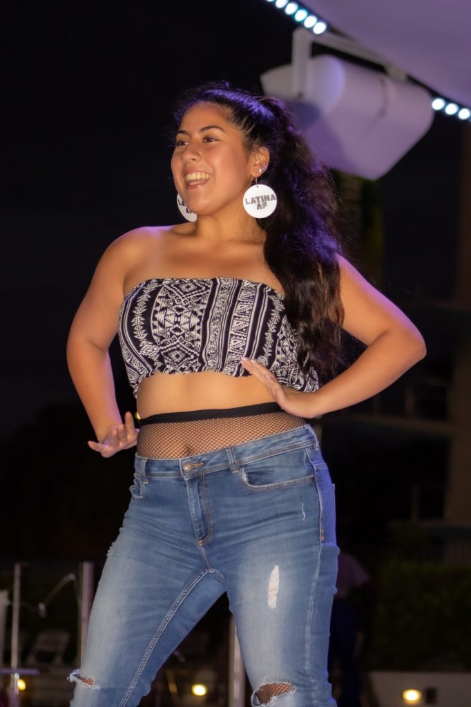 A UThrift model smiles at the crowd at the end of the runway during the student-led fashion show on Wednesday, Oct. 20 at the Lakeside Patio. The UThrift even began at 5:30pm and included various activities promoting the benefits of recycling clothing.