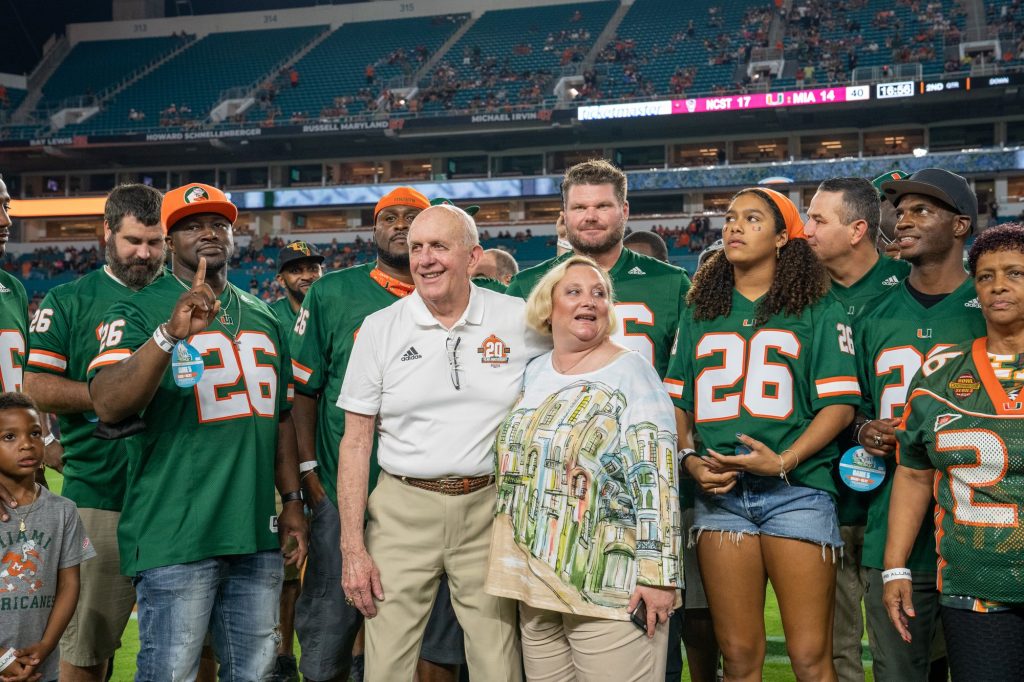 National champion head coach Larry Coker poses with former players and family members during a halftime ceremony recognizing the 2001 national champions at Miami’s game versus NC State University at Hard Rock Stadium on Oct. 23, 2021.
