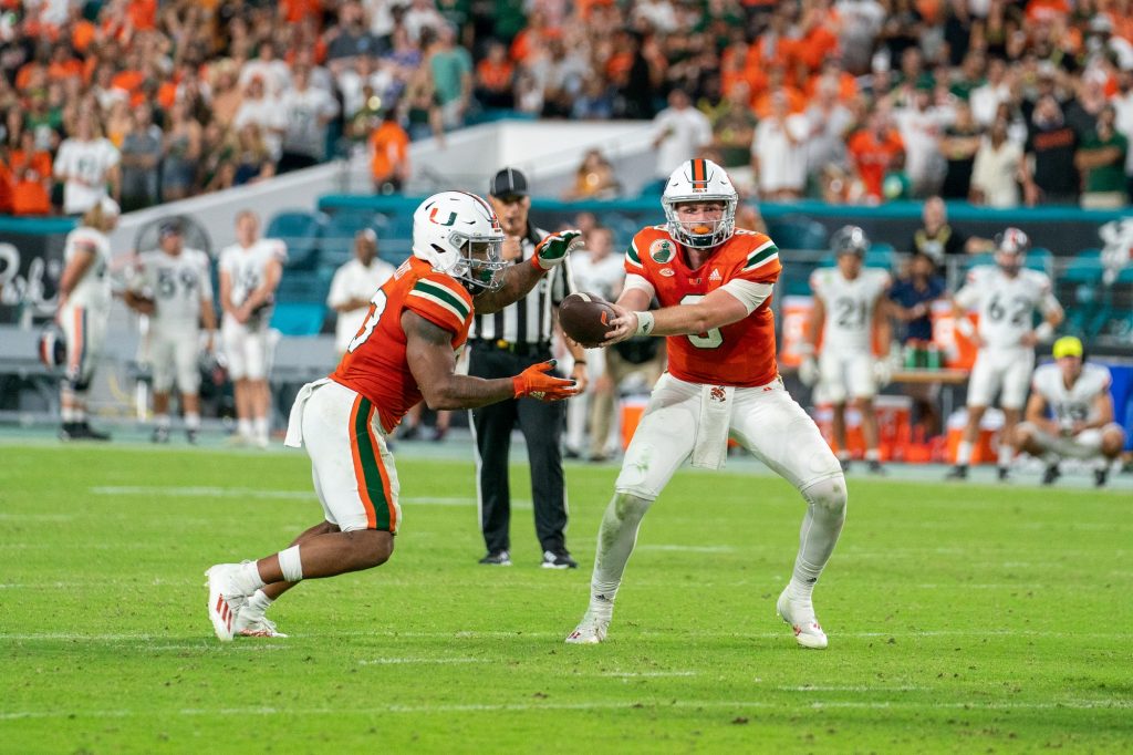 Freshman quarterback Tyler Van Dyke hands off the ball to junior running back Cam’Ron Harris during the fourth quarter of Miami’s game versus the University of Virginia at Hard Rock Stadium on Sept. 30, 2021.
