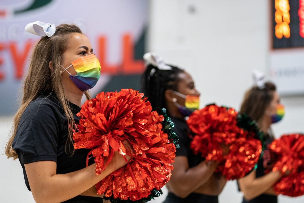 Members of UCheer, wearing pride-themed face masks, perform during a timeout in the second set of Miami’s match versus the University of North Carolina in the Knight Sports Complex on Oct. 1, 2021.