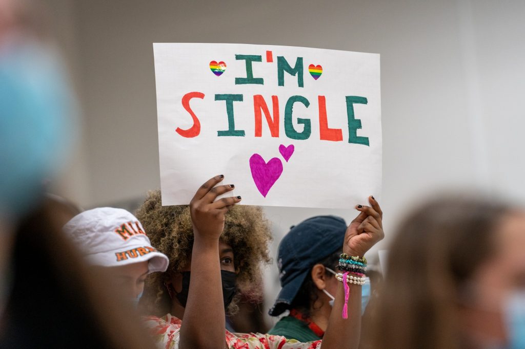 A spectator holds up a sign reading “I’m single” during the second set of Miami’s match versus the University of North Carolina in the Knight Sports Complex on Oct. 1, 2021.