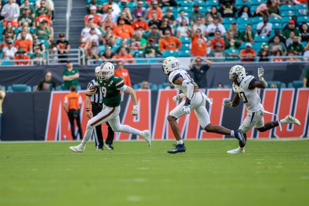 Freshman quarterback Tyler Van Dyke runs to the outside in an attempt to evade two Georgia Tech defenders in Miami’s win on Saturday Nov. 6 at Hard Rock Stadium.