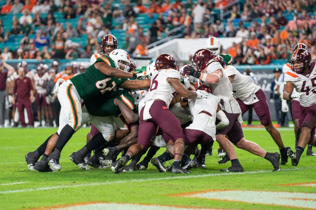 Miami players shove the pack and freshman running back Jaylan Knighton into the end zone for a touchdown during the second quarter of Miami’s game versus Virginia Tech at Hard Rock Stadium on Nov. 20, 2021.