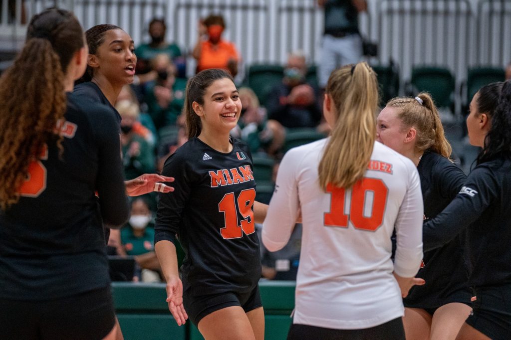 Members of the canes volleyball team celebrate after scoring a point during the second set of their match versus Boston College in the Knight Sports Complex on Oct. 31, 2021.