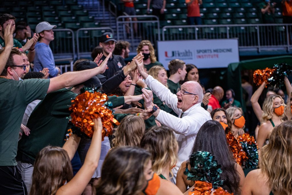Head Coach Jim Larrañaga celebrates with students after leading Miami to their first conference win of the season against Clemson on Saturday, Dec. 4 at the Watsco Center. Larrañaga is in his 10th season at Miami.