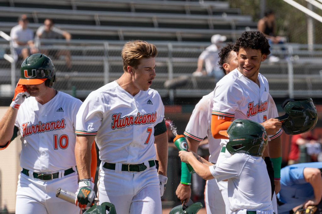 Sophomore outfielder Jacob Burke is showered with water by a Miami bat boy after hitting for a three-run home run in the bottom of the first inning of Miami’s game versus Harvard at Mark Light Field on Feb. 27, 2022. The home run brought the score to 4-0.