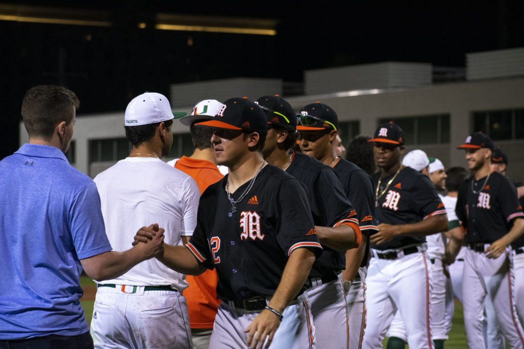 Miami baseball players interact with members of the annual alumni game's Alumni Team following the Hurricanes' 13-0 victory on Feb. 12, 2022 at Mark Light Field