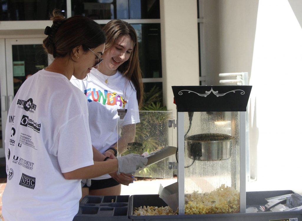 Sophomores Michelle Manfrini and Elena Hoffman pop popcorn for guests at FunDay on Saturday, Feb. 26, 2022. They came to FunDay to help host a game for the FunFair as members of the American Medical Student Association.