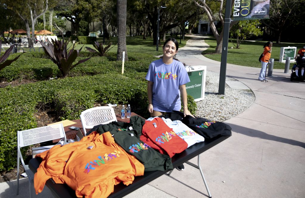 Freshman Taylor Kares distributes shirts to participants at the University of Miami's 39th  Annual Funday on February 26, 2022.