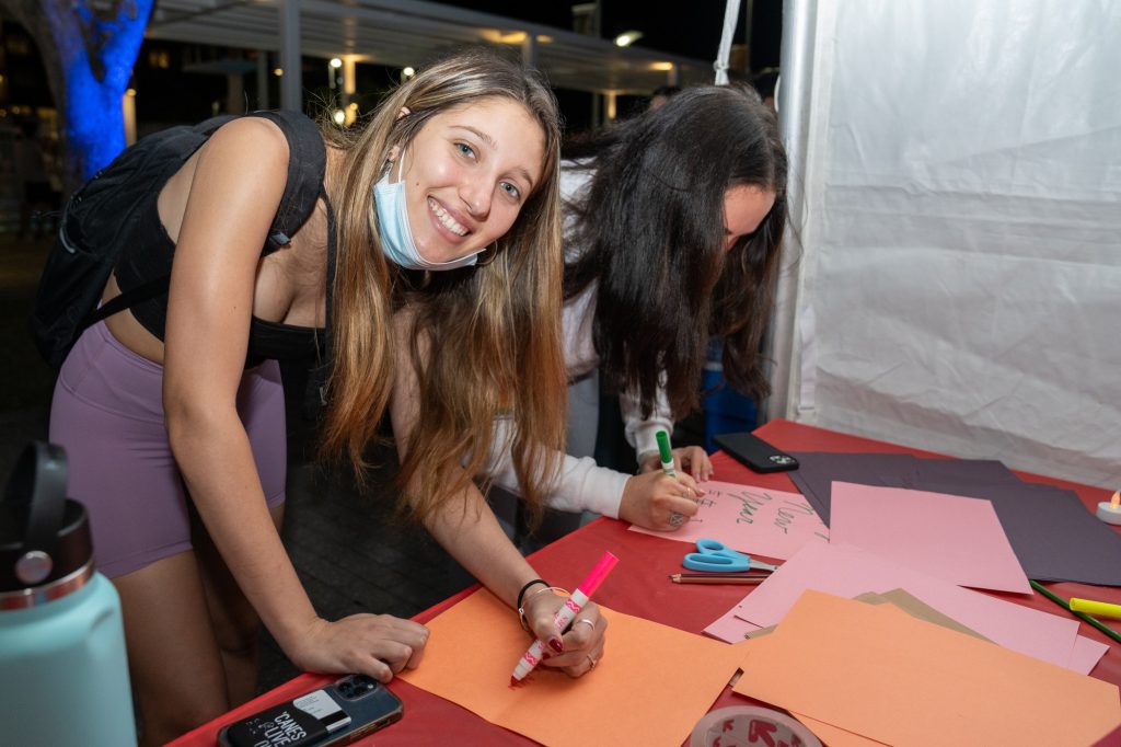 Freshman Abby Stern writes new year wishes in one of many booths celebrating and showcasing different parts of Asian culture during the Lunar New Year Festival on the Lakeside Patio on Feb. 7, 2022.