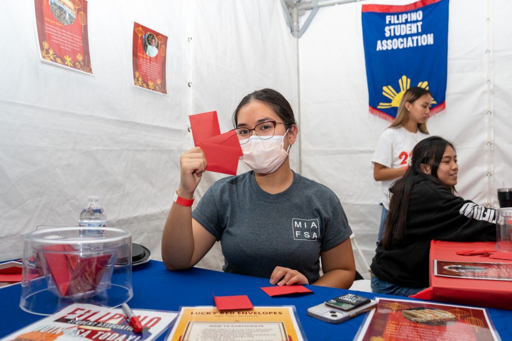Gabrielle Yamar holds up three Lucky Red Envelopes in the Filipino Student Association’s booth at the Lunar New Year Festival on the Lakeside Patio on Feb. 7, 2022.