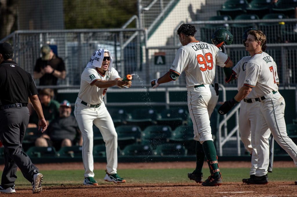 Sophomore Carlos Perez sprays freshman Lorenzo Carrier after Carrier hit his first home-run as a Miami Hurricane in Miami's 11-2 win in the first game of their doubleheader against Towson at Mark Light Field on Saturday, Feb. 19. Carrier recorded three RBIs on two hits.