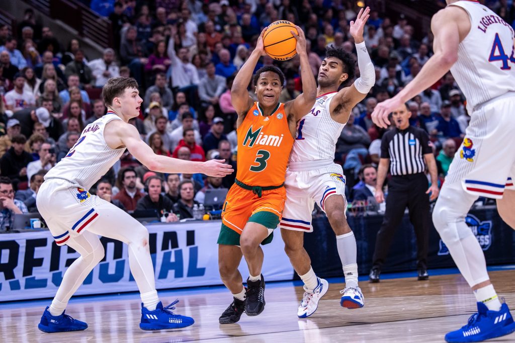 Sixth-year redshirt senior Charlie Moore dribbles past two Kansas defenders in Miami's loss in the Elite Eight at the United Center in Chicago on Sunday, March 27, 2022.