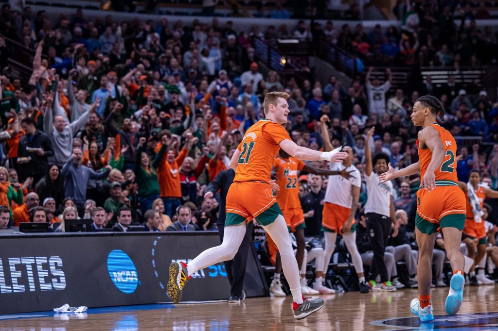 Sixth-year redshirt senior Sam Waardenburg high-fives third-year sophomore Isaiah Wong after hitting a three point shot during the first half of Miami's Elite 8 matchup against Kansas on Sunday, March 27, 2022 at the United Center in Chicago.
