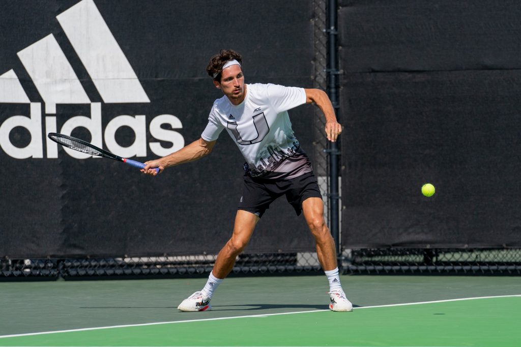 Senior Benjamin Hannestad returns the ball during the seventh game of the first set of his singles match versus Seminole junior Andreja Petrovic at the Neil Schiff Tennis Center on March 30, 2022.