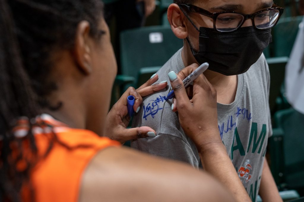 Graduate guard Kelsey Marshall signs an autograph on a fan’s shirt after the Canes’ 76-40 victory over the Clemson Tigers in The Watsco Center on Feb. 27, 2022.