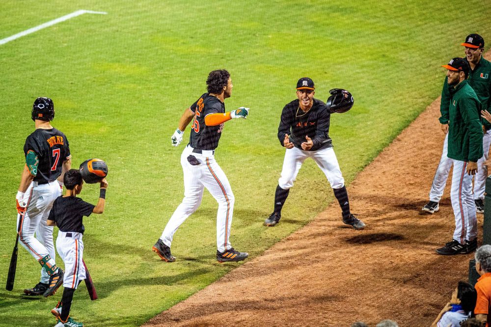 Sophomore Yohandy Morales celebrates his game-winning home run with teammates in the seventh inning of No. 8 Miami’s 5-4 win over No. 3 Virginia on Saturday, April 9, 2022 at Mark Light Field.