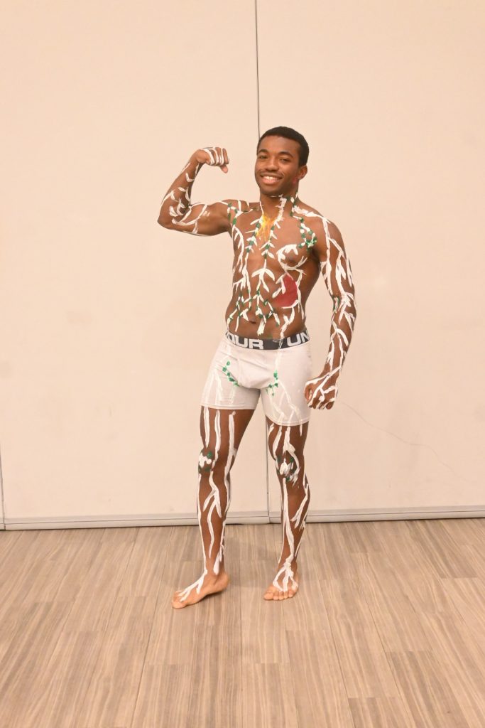 An fashion show participated shows off his body paint before going on stage.