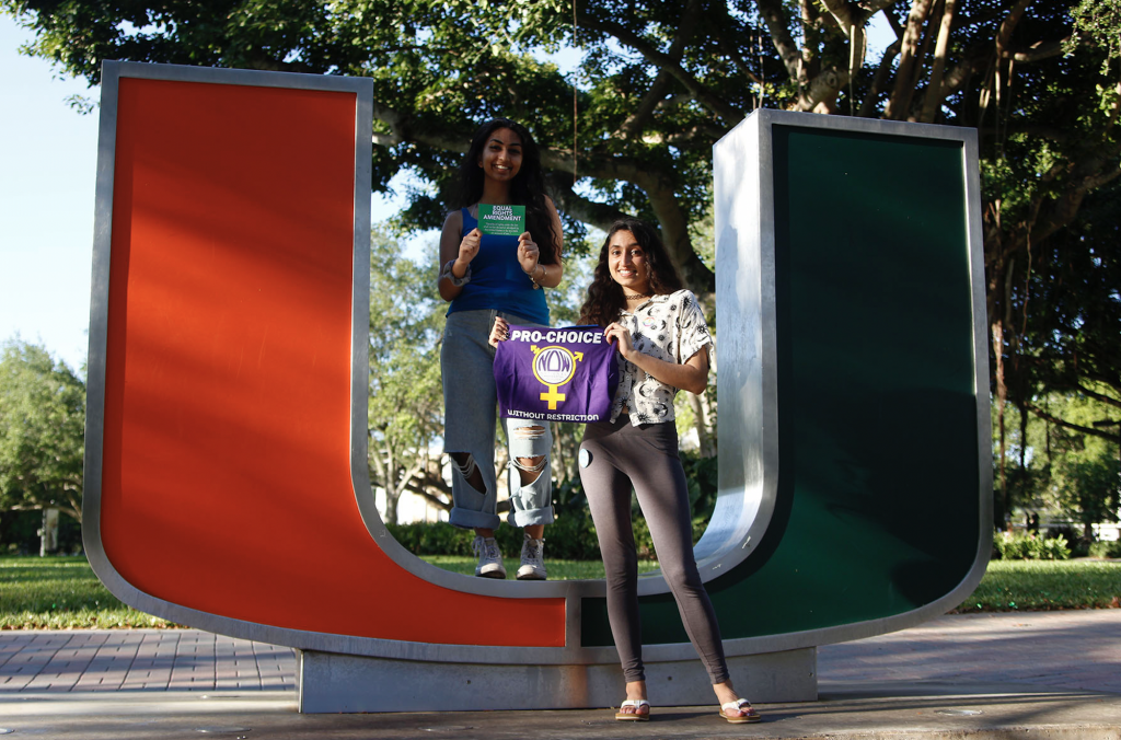 Bhavya Sharma and Lauren Colaco pose in front of the U statue on campus.