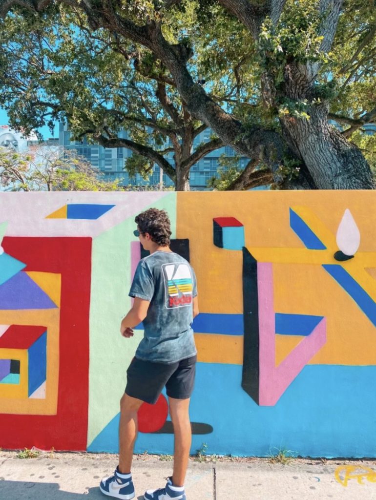 UM student, Quentin Asencio, photographed in Wynwood in front of a mural on May 2, 2021.