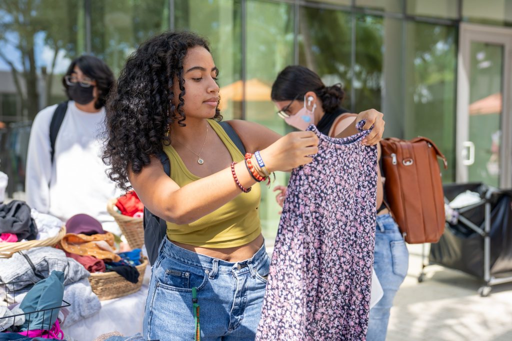 Junior Keyra Juliana looks at a skirt at UThrift’s first popup thrift swap event of the semester on Sept. 8, 2021.