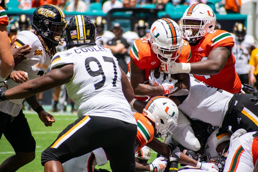 Third-year sophomore running back Henry Parrish, Jr. jumps over a pile of Southern Miss defenders during Miami's 30-7 win on Sept. 10 at Hard Rock Stadium.