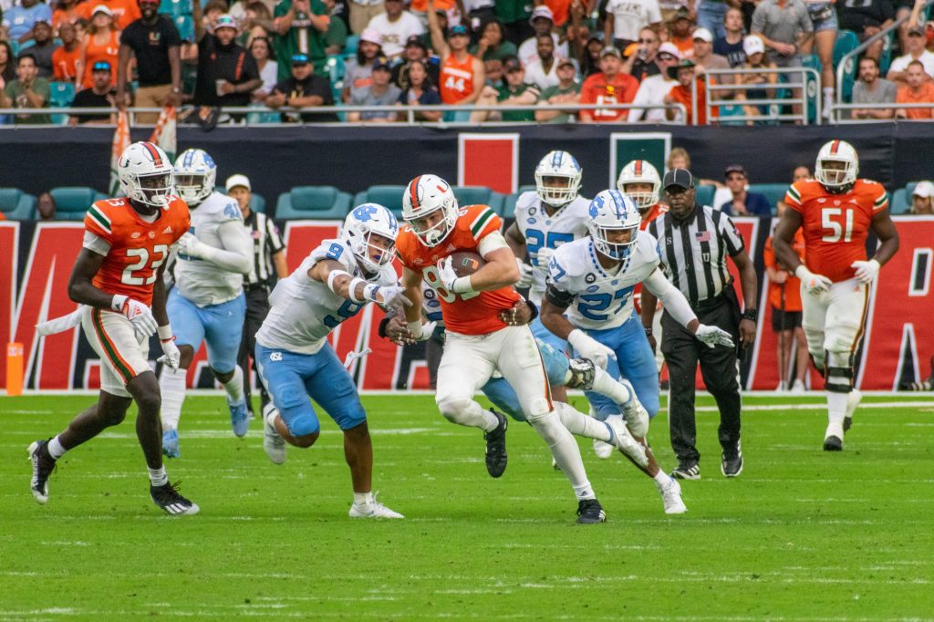 Fifth-year senior tight end Will Mallory rushes through defenders during Miami's game against the University of North Carolina on Saturday, Oct. 8 at Hard Rock Stadium.